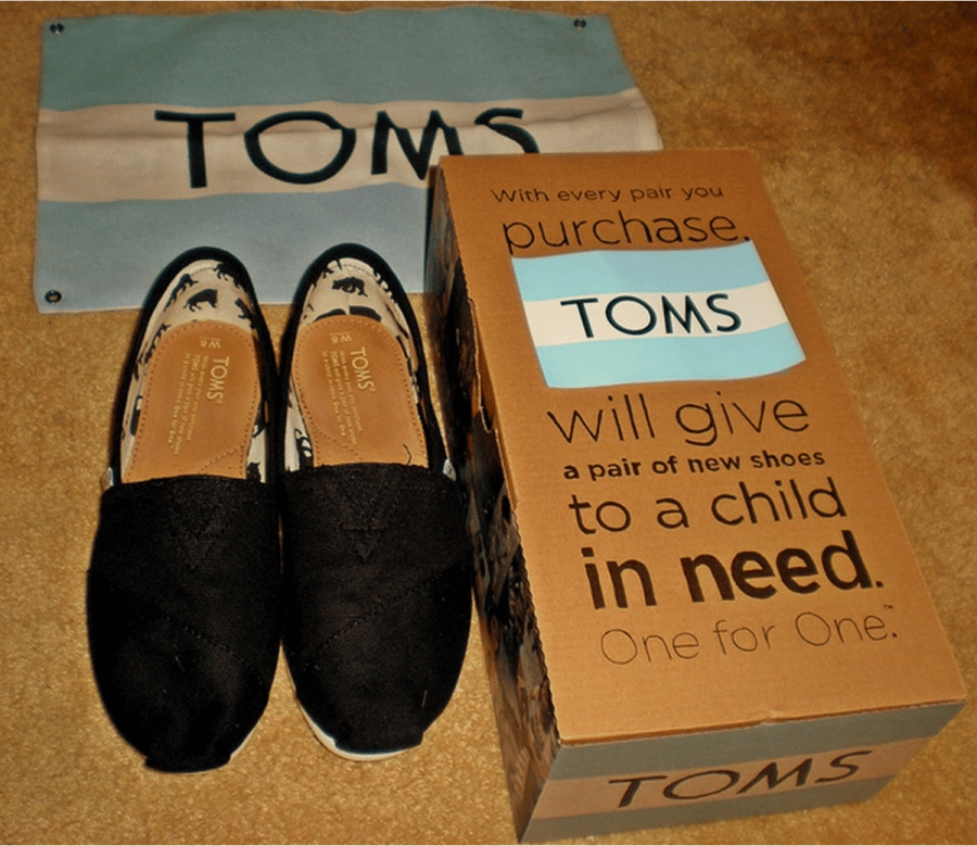 Toms gives a pair of shoes to children in need